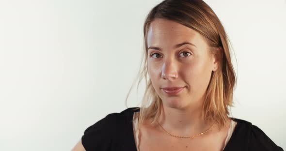 Close up of a young blond woman smiling on white studio background alt