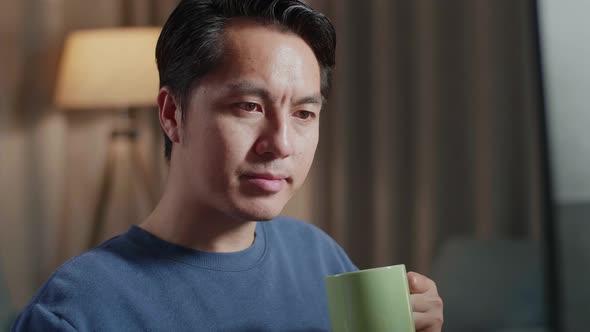 Asian Male Engineer With The House Model Drinking Coffee While Working On A Desktop At Home alt