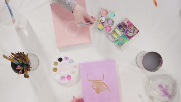 Flat lay. Little girl painting with acrylic paint on canvas with her mother for a distant learning a alt