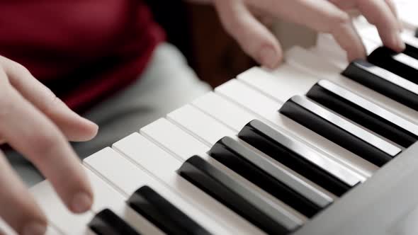 Close up of woman's hand playing on the electric piano. Female synthesizer player. alt