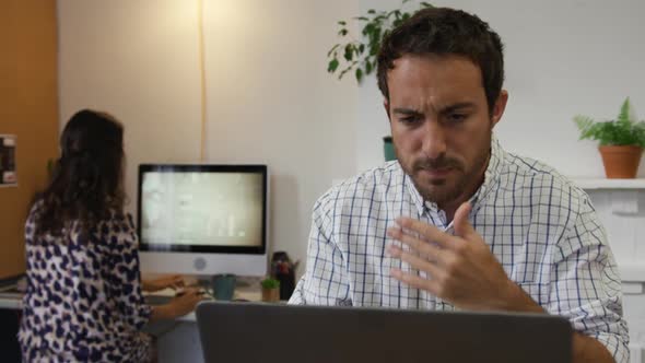 Millennial male professional working in a creative office alt