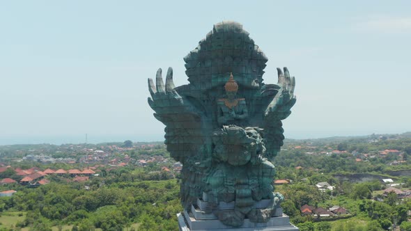 Front Rotating Aerial View of Majestic Copper and Brass Garuda Wisnu Kencana Statue in Bali alt