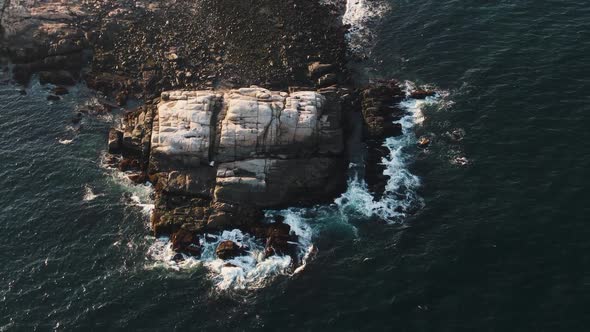 Stunning Shot Of Deep Blue Ocean With Foamy Waves Splashing In Slow Motion On The Rocks In Glouceste alt