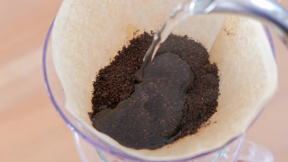 Water pouring to the coffee filter, making of hand drip coffee alt