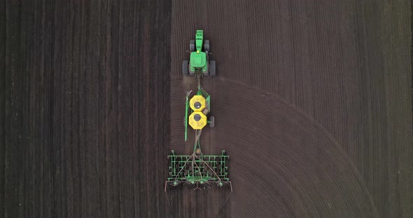 Tractor with a Seeder in a Field Aerial View