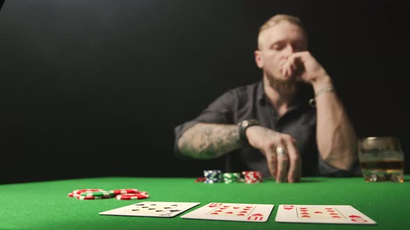 Man Raising the Bet with Red Chips During Poker Game. Space To Add Text