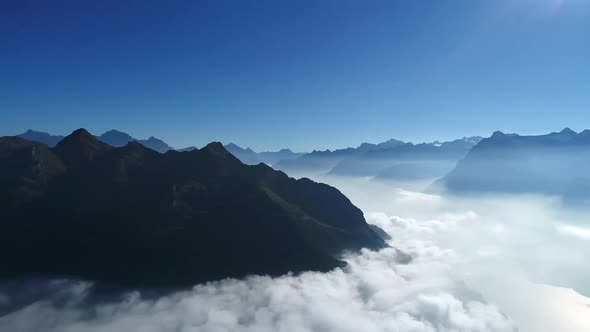 Aerial view of low lowing clouds covering the mountain peaks of the Swiss Alps, Switzerland (3) alt