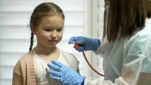 Female Doctor Listens with a Phonendoscope to a Girl Patient 78 Years Old Patient alt