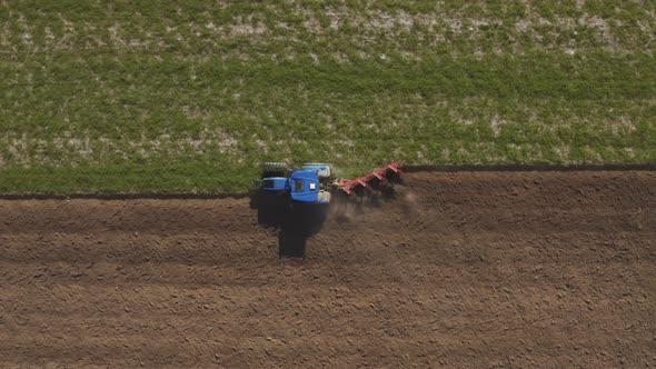 Aerial view of a tractor plowing a field in Lomellina, Po Valley, Italy. alt