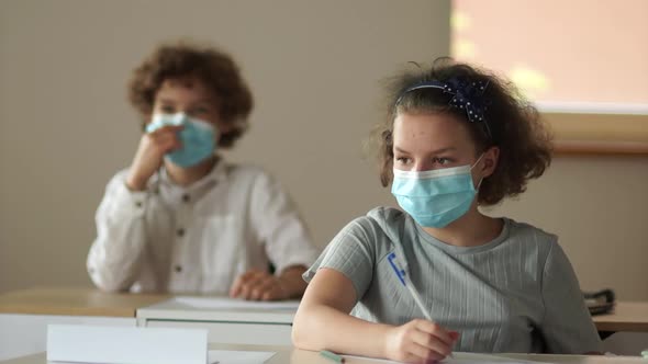 Kids Face Mask. Back To School Covid. Children in Protective Medical Masks Sit at Their Desks at alt