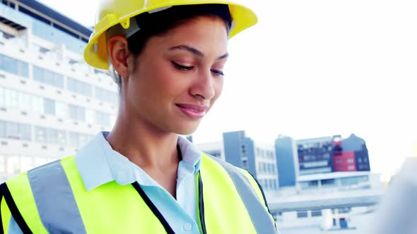 smiling engineer looking at blueprints alt