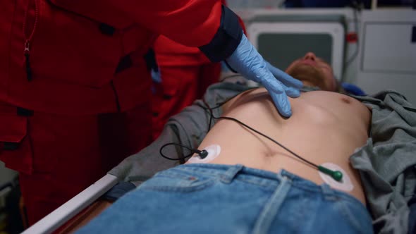 Paramedic Hands Performing CPR of Injured Man on Stretchers in Emergency Car alt