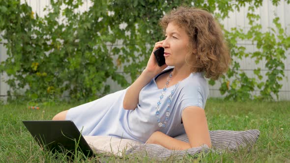 Lady with notebook working outdoor. Office outdoor. Working on fresh air. Phone talking concept