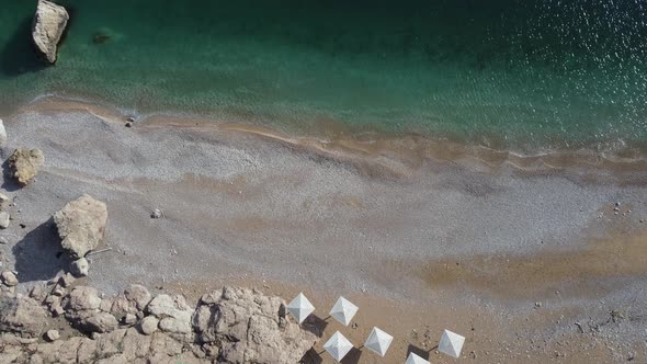 Aerial View From Above on Azure Sea and Pink Pebbles Beach alt