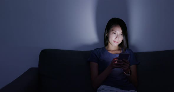 Woman use of cellphone at home in the evening alt