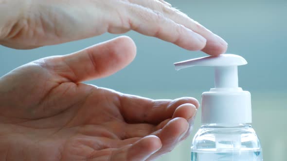 Male Hands Push the Dispenser and Squeeze Out Liquid Soap