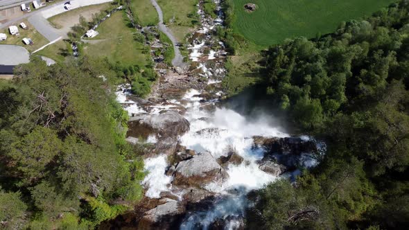Flying over the edge of famous tourist attraction Tvindefossen waterfall in Voss Norway - Birdseye a alt