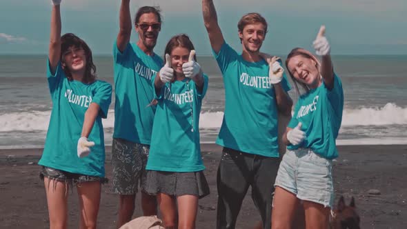 Volunteers Showing Thumbs Up on the Ocean Beach Celebrating Victory alt