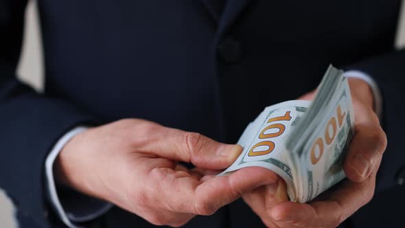 Formally Dressed Man Counting US Dollar Bills alt