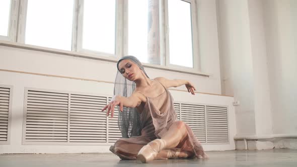 Graceful Ballet Dancer in Grey Scenic Suit Performing on Pointes on Grey Studio alt