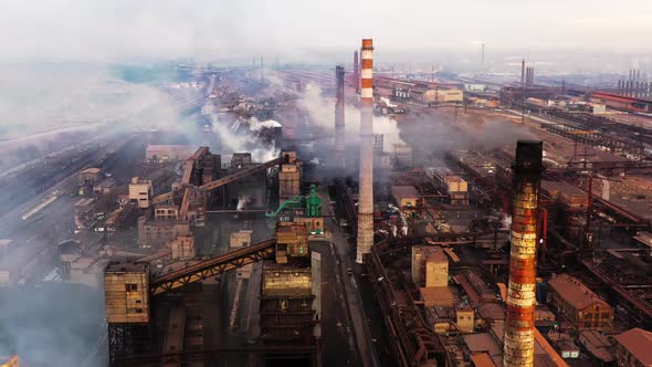 Aerial. GLOBAL WARMING. View of High Chimney Pipes with Grey Smoke. Pipes Pollute Industry