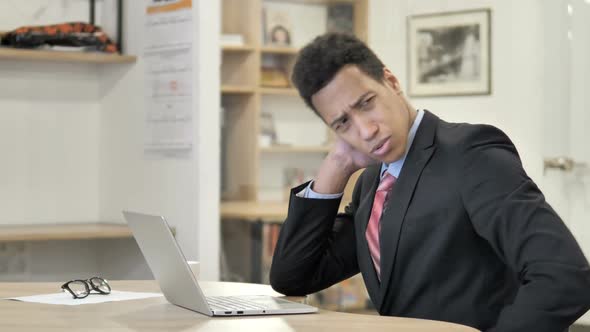 Tired African Businessman with Neck Pain Working on Laptop alt