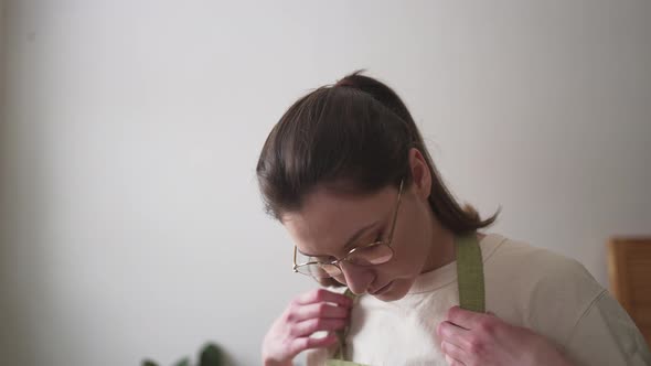 Florist with Glasses Wears a Green Apron