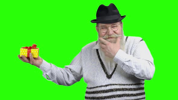 Older Man Pointing with Finger at Gift Box alt