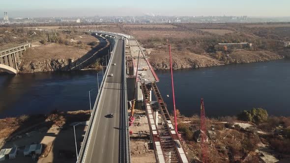 Zaporozhye, Ukraine. Aerial view of the bridge across the Dnieper. The car travels on one half. alt