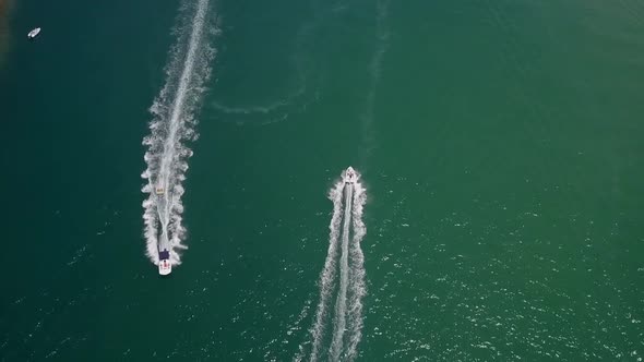 Recreation boaters enjoy vivid green lagoon on warm sunny day, aerial alt