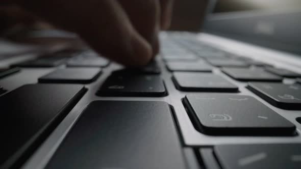 Close-up typing on keyboard with man fingers. Macro soft focus dolly shot. alt