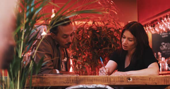 Man and a woman discussing papers alt