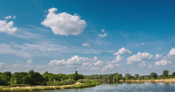 River Among Green Bushes and Trees with Clouds Above It alt