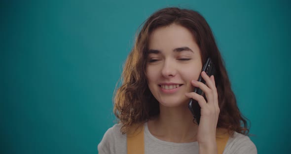 Happy Attractive Young Woman is Speaking on Smartphone alt