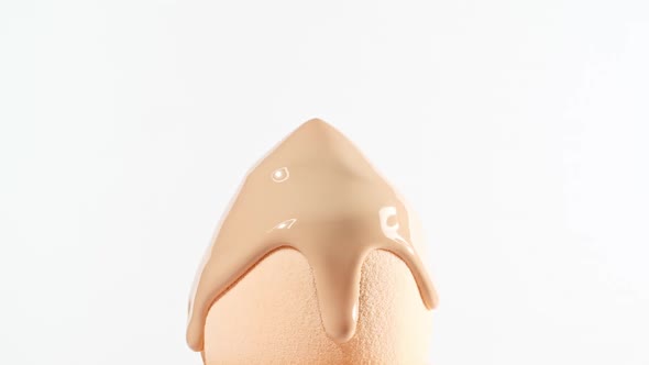 Makeup Liquid Beige Foundation Pouring on Sponge Closeup alt