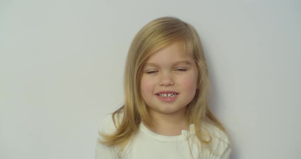 Portrait Little Girl and Looking at Camera. Young Laughs Happily Child Looking at Camera. Closeup alt