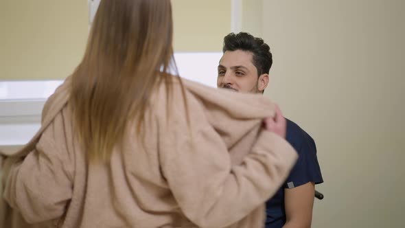 Medium Shot of Smiling Positive Male Plastic Surgeon Oncologist Sitting in Ward As Female Patient alt