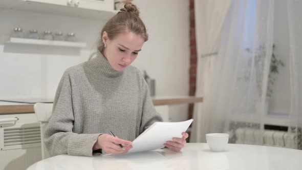 Young Woman Reacting To Failure and Reading Documents alt