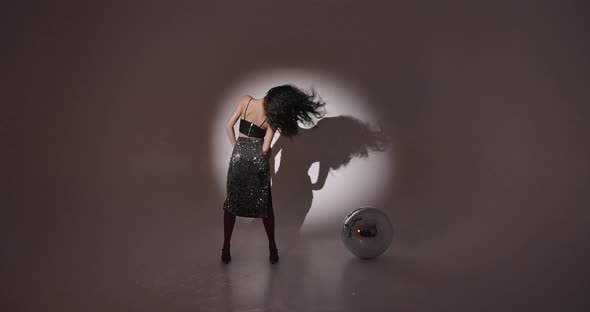 Young Woman Salsa Dancer Posing Under Projectors Light alt