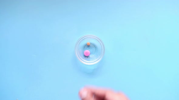 Close Up of Medical Pills and Capsules in a Small Container on Blue Background alt