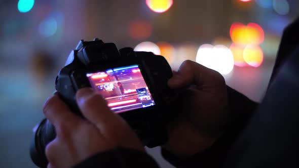 Photographer At Night Reviewing Picture With Beautiful Bokeh