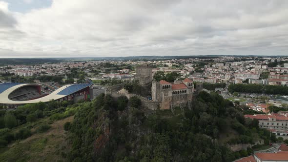 Hilltop Leiria Castle and the city soccer stadium. Wide aerial cityscape shot