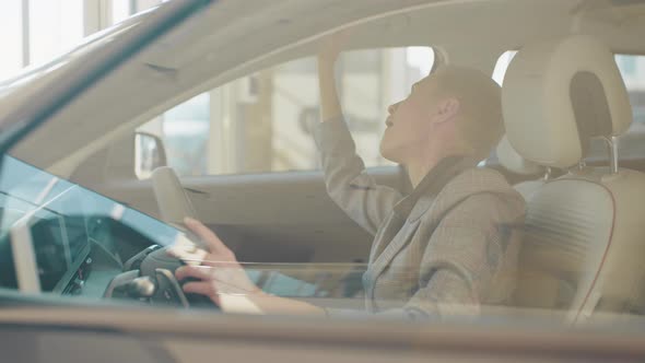 Caucasian Female Customer Testing Auto Before Making Purchase alt