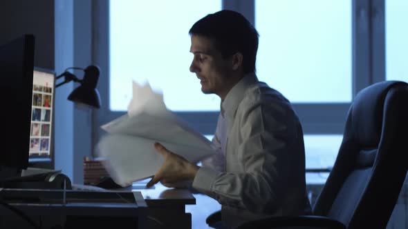 Angry Businessman in Formalwear Working on Computer in Office at Night Then Throws Papers