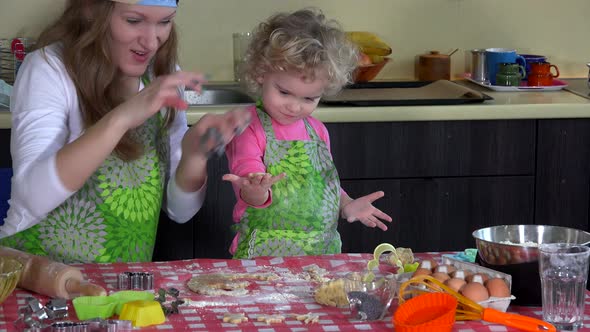 Mother and Child Cutting out Christmas Cookies from Dough at Home Kitchen