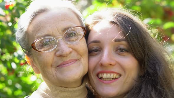Happy Senior Mother in Eyeglasses is Hugging Her Adult Daughter the Women are Enjoying Together alt