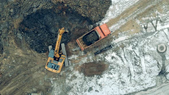 Industrial Digger is Excavating Soil in a Top View alt