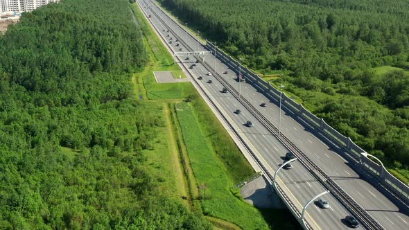 Asphalt Speedway with Cars Through Green Field. Aerial View From Drone alt