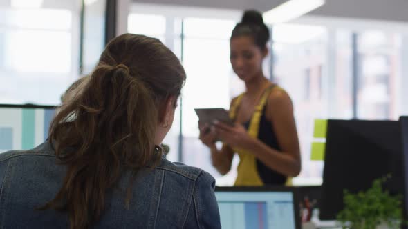 Two diverse female work colleagues giving high five and smiling alt