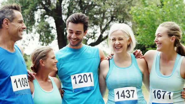Athletic family standing together in the park alt